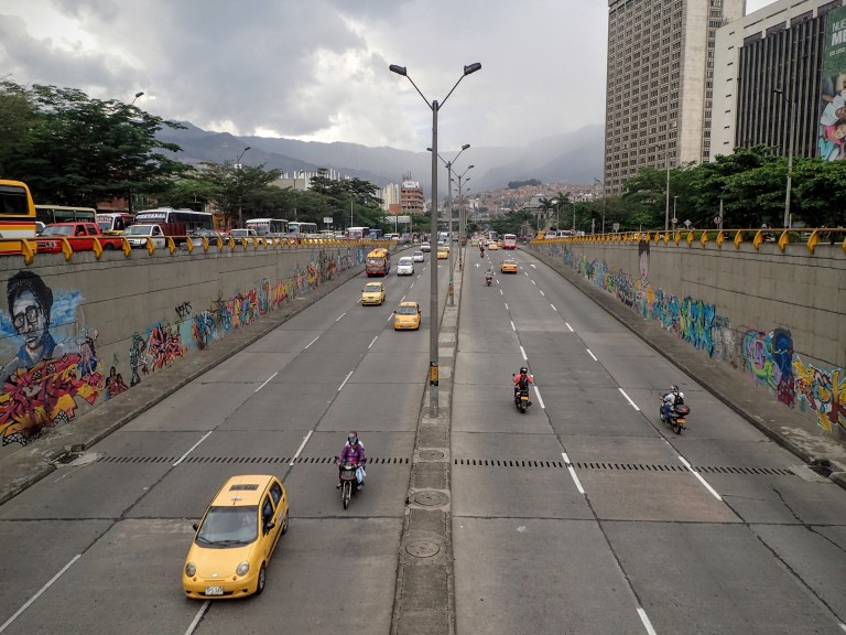 A clean city street in Medellin, Colombia. Local graffiti art covers the walls. 
